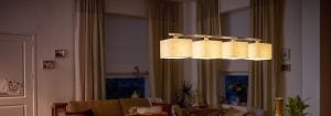 Šiuolaikinis LED pakabinamas šviestuvas su keliais audinio gaubtais apšviečia jaukią svetainę, demonstruodamas energiją taupančius ir stilingus namų apšvietimo sprendimus, užtikrinančius vakaro komfortą.
